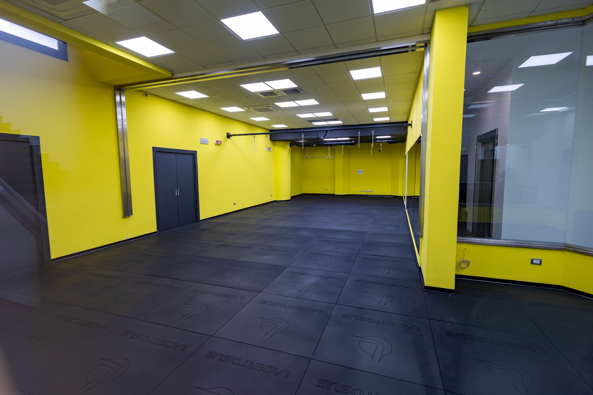 Approx. 150 m² multipurpose room on the lower-ground floor, with fluorescent yellow walls